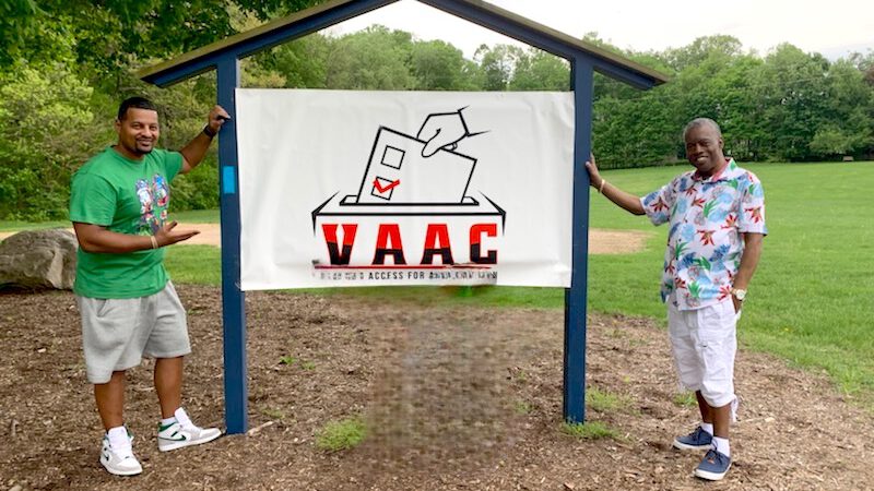 Danny Jones and Earl Burton standing next to a VAAC banner