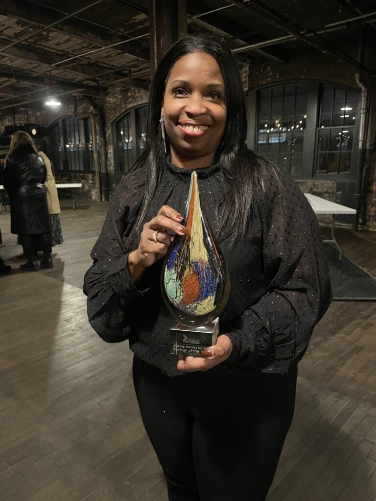 Angela Davenport with the Partner of the Year Award, presented to Voting Access for All Coalition by Michigan Voices.
